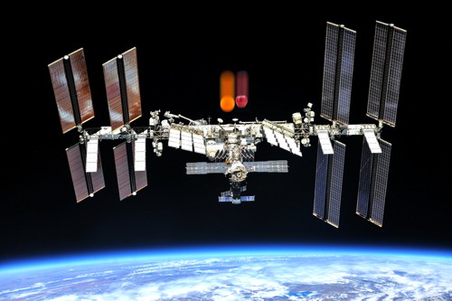 Mezinárodní vesmírná stanice, nad niž symbolicky padají pomeranč a jablko