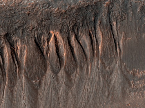 Snímek ukazuje stěnu impaktního kráteru v oblasti Ariadnes Colles s řadou malých stružek, tzv. gullies