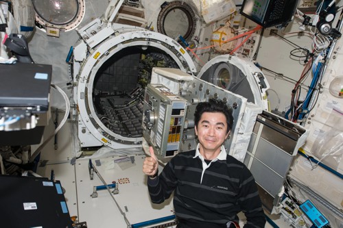 Japonský astronaut Kimiya Yui připravuje experimentální panel s bakteriemi
